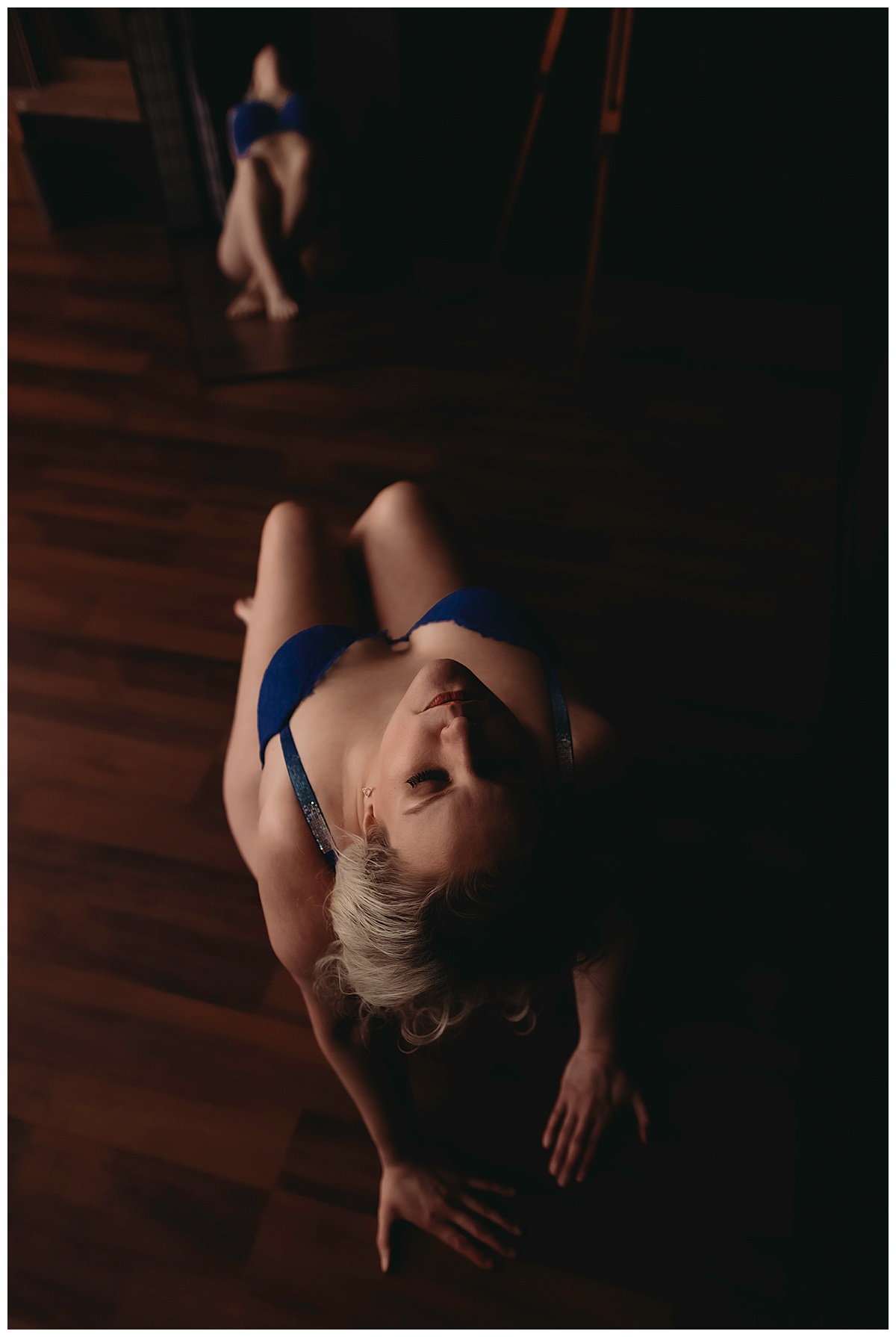 Woman leans back in blue outfit for Boudoir Photography Minnesota
