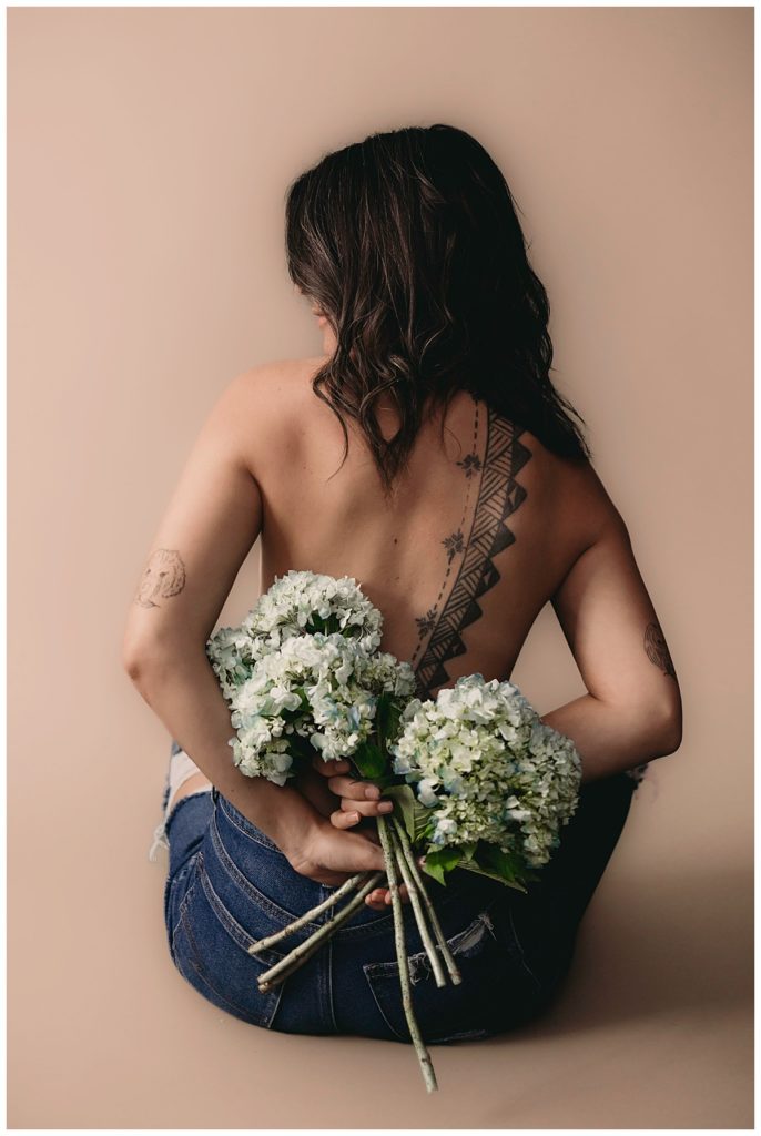 Adult holds flowers behind back for Minneapolis Boudoir Photographer