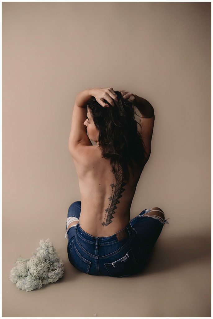 Tattooed person holds hands to head for Minneapolis Boudoir Photographer